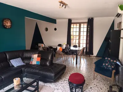 a living room with a black leather couch and a table at El terret in Sigean