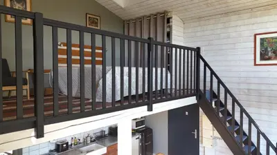 a staircase with black railings in a house at Gites Arnoult in Damiatte