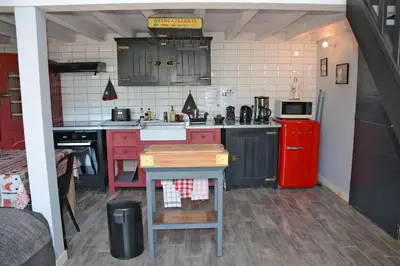 a kitchen with red cabinets and a red refrigerator at Gites Arnoult in Damiatte