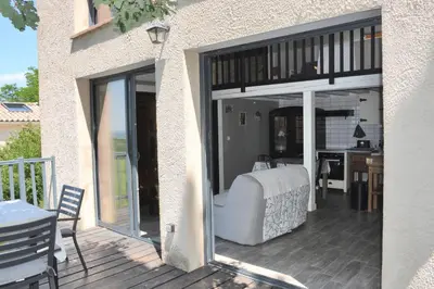a bedroom with sliding glass doors on a deck at Gites Arnoult in Damiatte