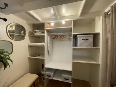a walk in closet with white shelves and a mirror at Pavillon confort pour 2 personnes GRUISSAN in Gruissan