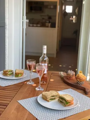 a table with two plates of sandwiches and glasses of wine at Pavillon confort pour 2 personnes GRUISSAN in Gruissan