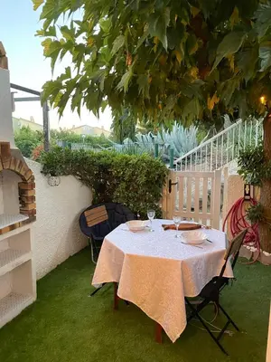 a table and chairs sitting under a tree at Pavillon confort pour 2 personnes GRUISSAN in Gruissan