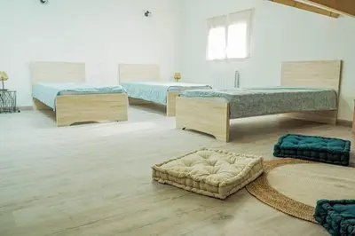 a room with three beds and a ottoman at La Porte du Midi in Mailhac