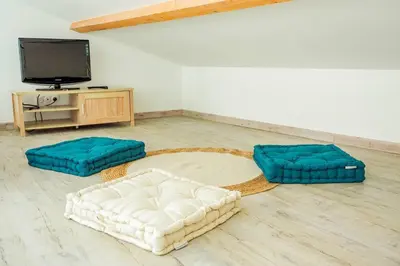 a living room with two ottomans and a television at La Porte du Midi in Mailhac
