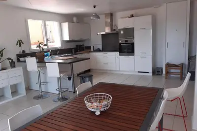 a kitchen with white cabinets and a table and chairs at Maison avec vue sur la mer et avec piscine à Fitou in Fitou