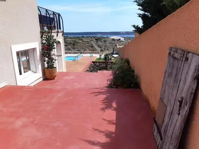 a red walkway leading up to a building with a pool at Maison avec vue sur la mer et avec piscine à Fitou in Fitou