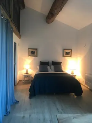 a bedroom with a large bed with two lamps at L Ostalada in Roquefort-des-Corbières