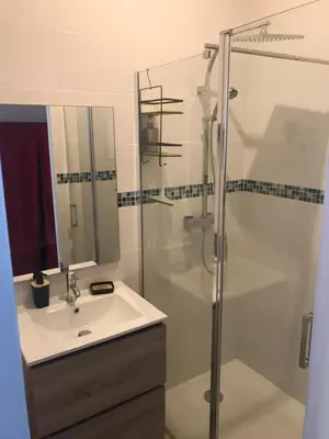 a bathroom with a glass shower and a sink at L Ostalada in Roquefort-des-Corbières