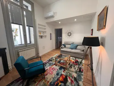 a living room with a couch and a chair at Les clématites in Narbonne