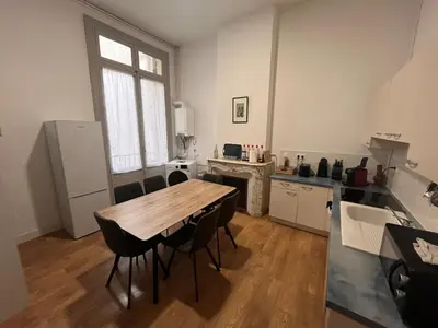 a kitchen with a table and chairs in a room at Les clématites in Narbonne