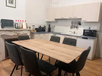 a kitchen with a wooden table and chairs at Les clématites in Narbonne