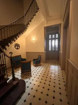 a hallway with a staircase with chairs and a table at Les clématites in Narbonne