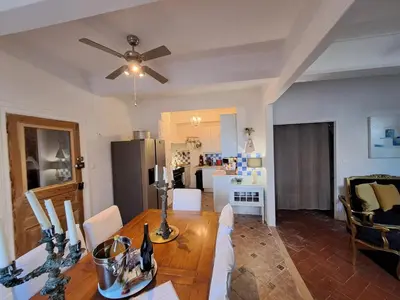 a kitchen and dining room with a table and a ceiling fan at La maison SPA, PISCINE et CLIMATISATION in Sainte-Vallière