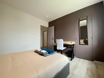 a bedroom with a desk and a bed with a window at Maison Tommy in Carcassonne
