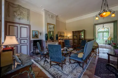 a living room with blue chairs and a table at Maison d'Hôtes de La Rivière in Pexiora