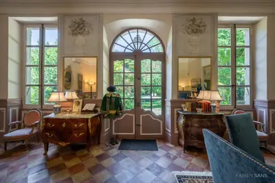 a living room with a large door and windows at Maison d'Hôtes de La Rivière in Pexiora
