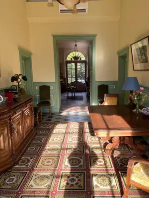 a living room with a table and a large rug at Maison d'Hôtes de La Rivière in Pexiora