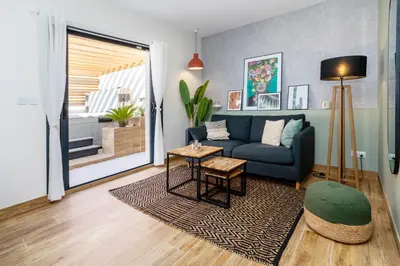 a living room with a blue couch and a table at L'entre deux-suite romantique - jacuzzi privatif - clim réversible - wifi in Le Somail