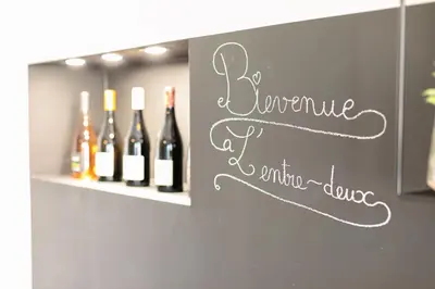a chalkboard sign with wine bottles on a wall at L'entre deux-suite romantique - jacuzzi privatif - clim réversible - wifi in Le Somail