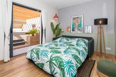 a bedroom with a bed with a green and white blanket at L'entre deux-suite romantique - jacuzzi privatif - clim réversible - wifi in Le Somail