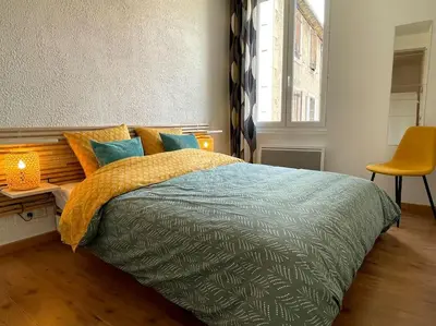 a bedroom with a bed and a desk with a chair at Pause Cathare in Chalabre