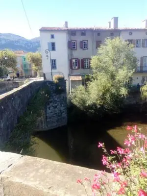 a bridge over a river next to a building at Chateau View Chambres d'hôtes in Quillan