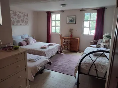 a bedroom with two beds and a desk and windows at Chateau View Chambres d'hôtes in Quillan