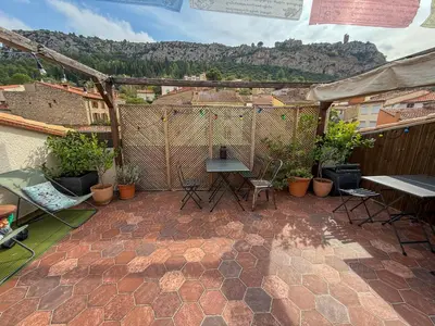 a patio with a table and chairs and plants at Origines in Tautavel
