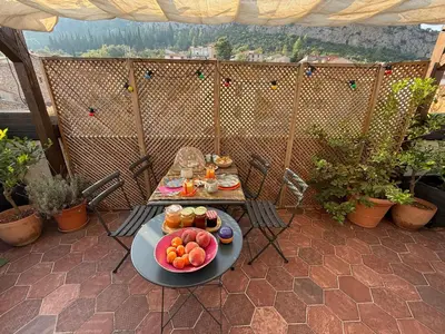 a table with a plate of fruit on a patio at Origines in Tautavel