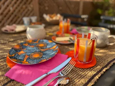 a table with a plate and a glass of orange juice at Origines in Tautavel