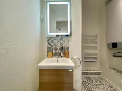 a bathroom with a sink and a mirror at Studios Sauzède - Carcassonne centre-ville in Carcassonne
