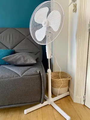 a white fan sitting on a floor next to a bed at Studios Sauzède - Carcassonne centre-ville in Carcassonne