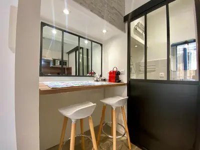 a bathroom with two stools at a counter with a mirror at Studios Sauzède - Carcassonne centre-ville in Carcassonne