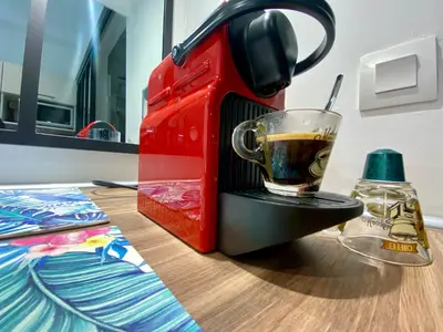 a red coffee maker with a cup on a table at Studios Sauzède - Carcassonne centre-ville in Carcassonne