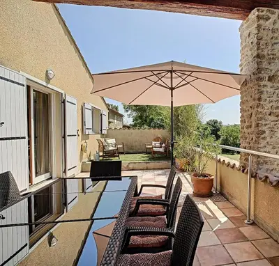 a patio with a table and chairs and an umbrella at Gîte - Holiday Home Vent Tramontane in Limoux