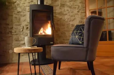 a living room with a chair and a fireplace at Gîte - Holiday Home Vent Tramontane in Limoux