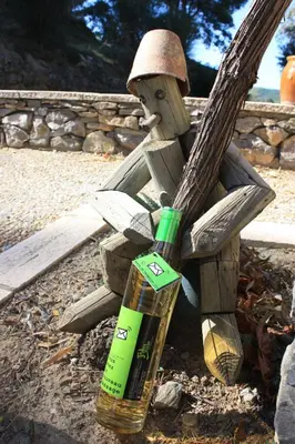 a bottle of alcohol sitting next to a wooden statue at Domaine de 