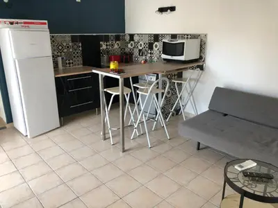 a small kitchen with a table and a refrigerator at Loft Toit Terrasse - Confort & Nature à Sigean in Sigean