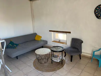 a living room with a couch and a table and a chair at Loft Toit Terrasse - Confort & Nature à Sigean in Sigean
