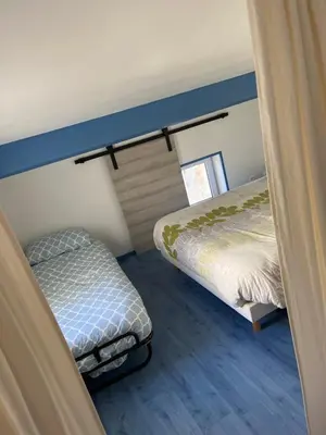 a room with two beds and a small bed and a window at Loft Toit Terrasse - Confort & Nature à Sigean in Sigean
