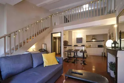 a living room with a blue couch and a staircase at CENTRE VILLE Appartement 75m2, avec 3 chambres in Carcassonne
