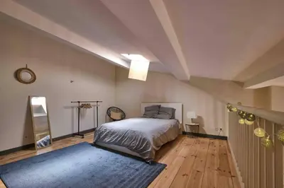 a bedroom with a bed and a blue rug at CENTRE VILLE Appartement 75m2, avec 3 chambres in Carcassonne