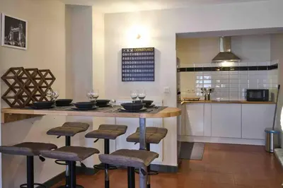 a kitchen with a bar with stools and a counter top at CENTRE VILLE Appartement 75m2, avec 3 chambres in Carcassonne