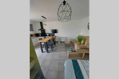 a living room with a table and a kitchen at Location studio entre garrigue et mer in Vinassan
