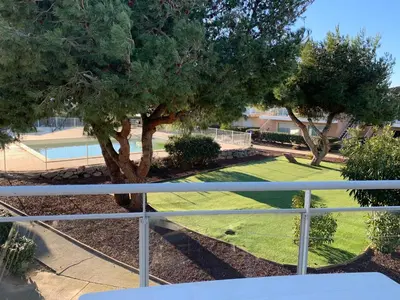 a view from a balcony of a yard with trees at T2 Les jardins Gruissan in Gruissan