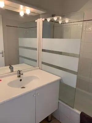 a white bathroom with a sink and a mirror at T2 Les jardins Gruissan in Gruissan