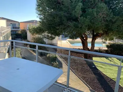 a white table on a balcony with a tree at T2 Les jardins Gruissan in Gruissan