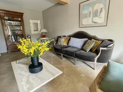 a living room with a couch and a vase with yellow flowers at Le Domaine de La Tuilerie - Gite de charme en bord de riviere avec piscine in Serviès-en-Val