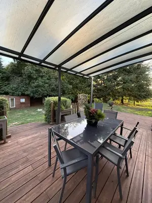 a patio with a table and chairs on a deck at Mon rêve in Les Martys